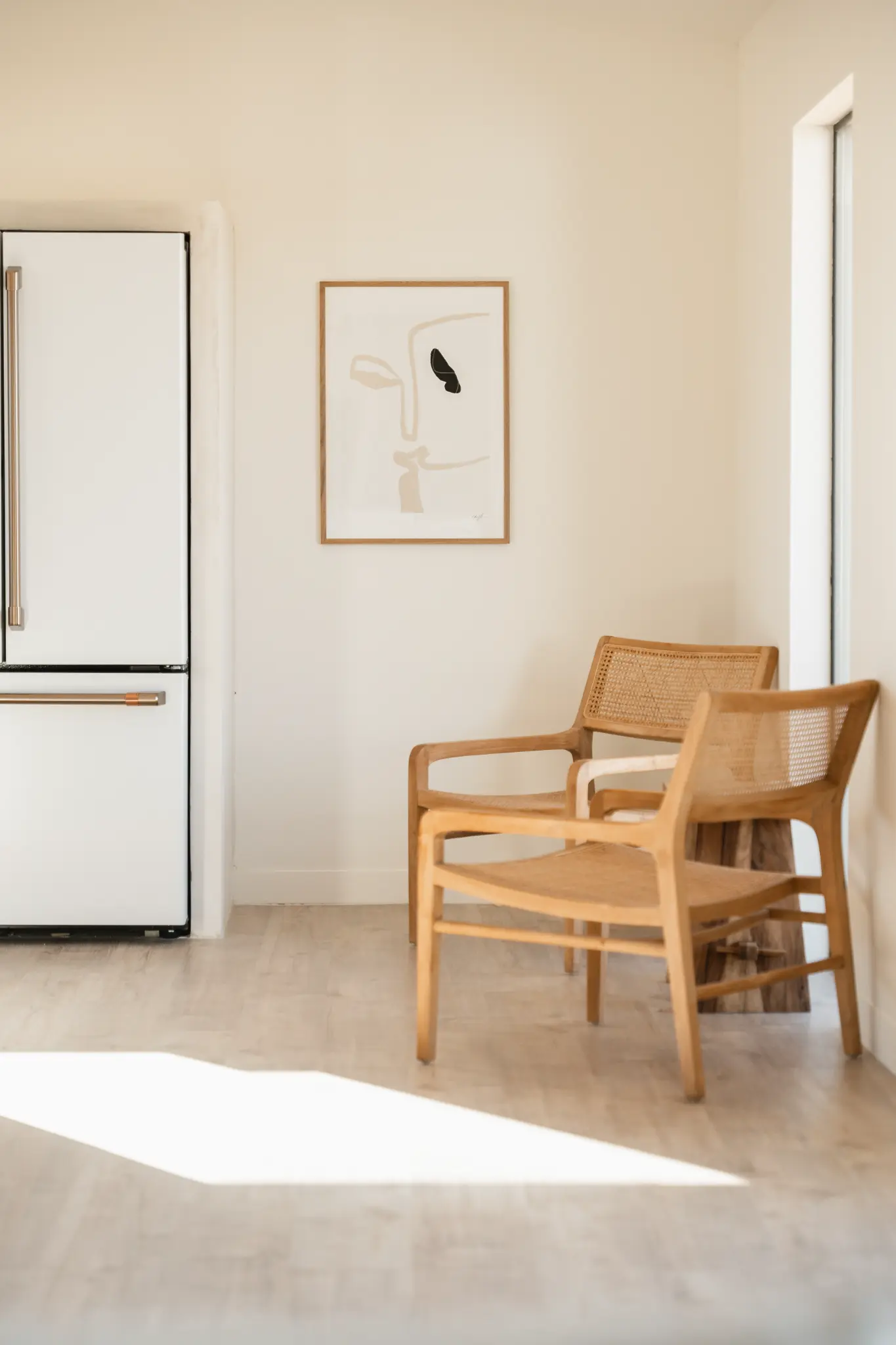 Kitchen with GE Café refrigerator and cane armchairs